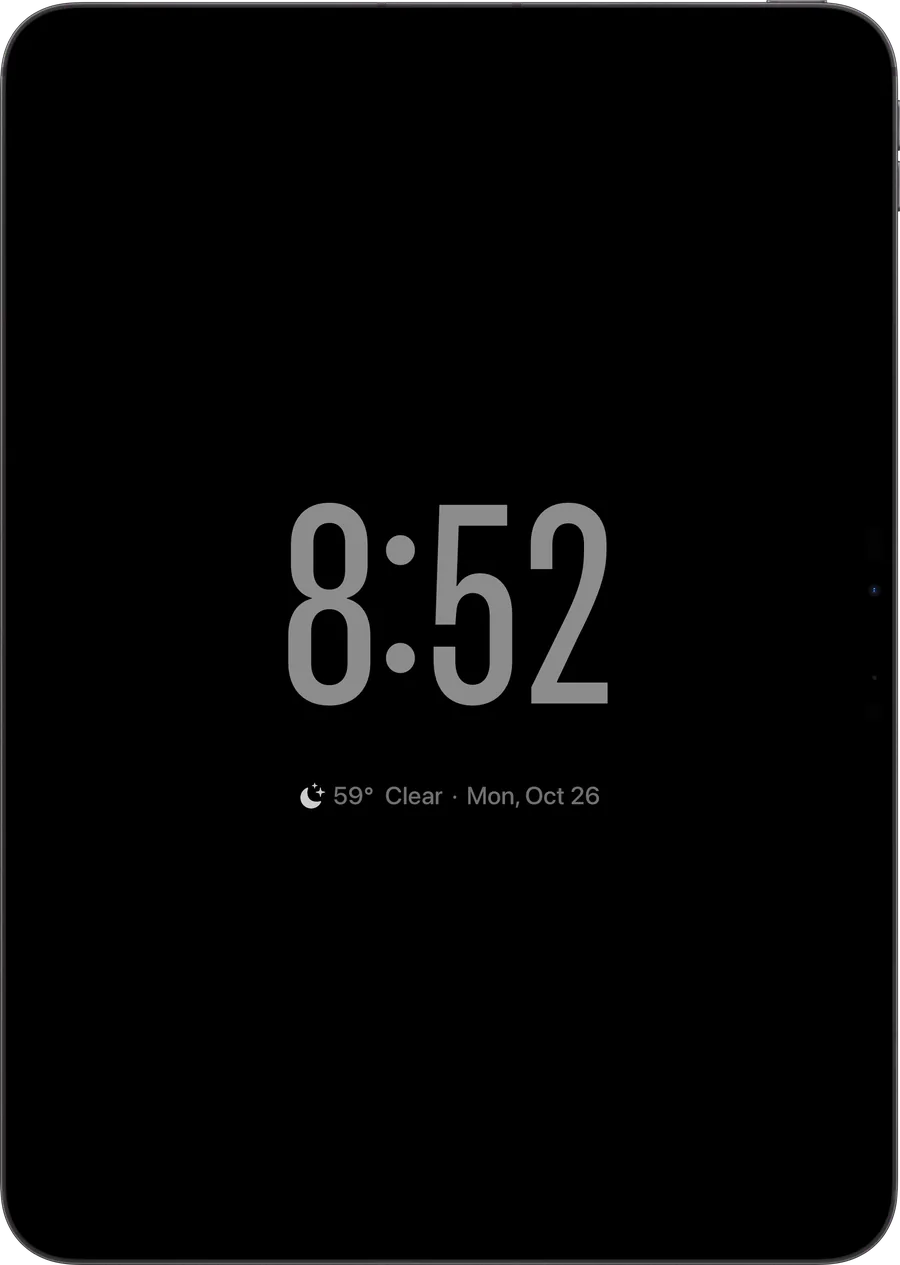 iPad in portrait showing a dim bedside clock reading 8:52